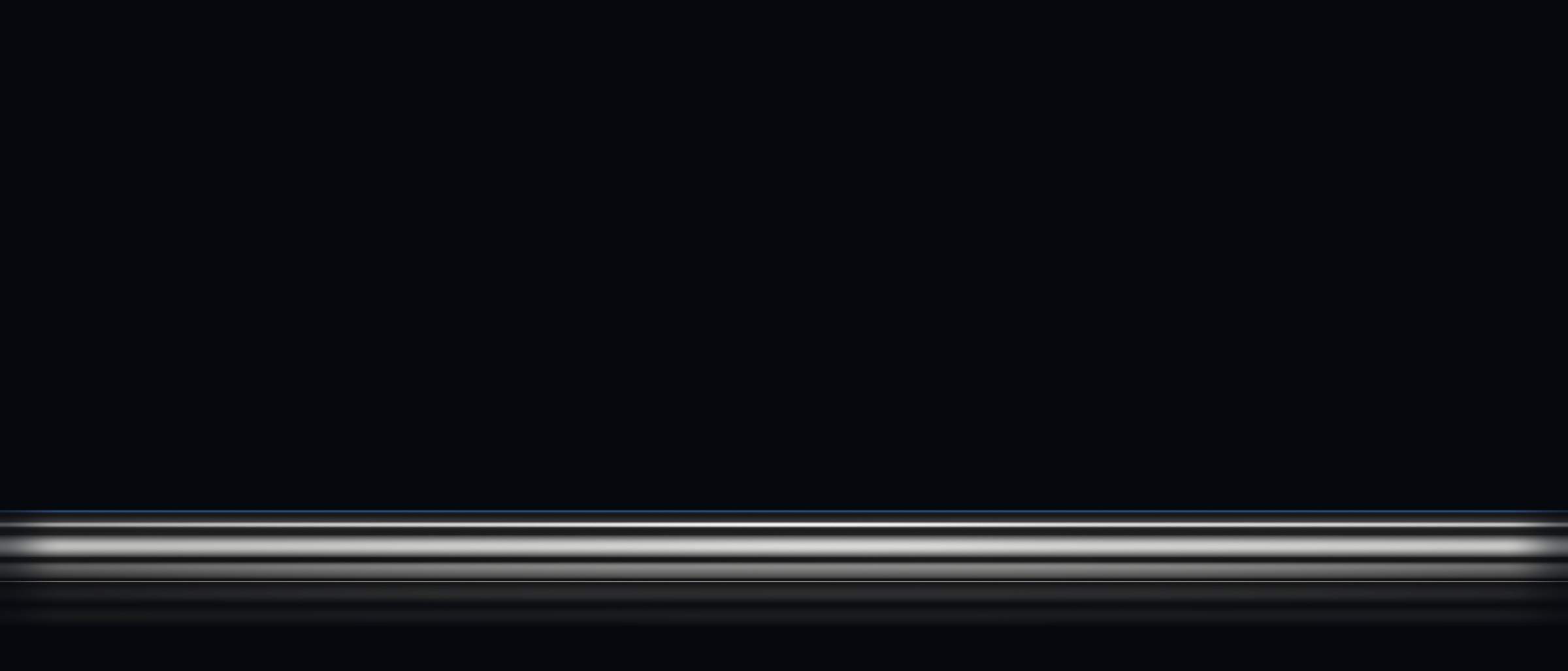 A chrome-plated hydraulic cylinder piston rod lying across the frame against a dark background, its polished surface catching the light