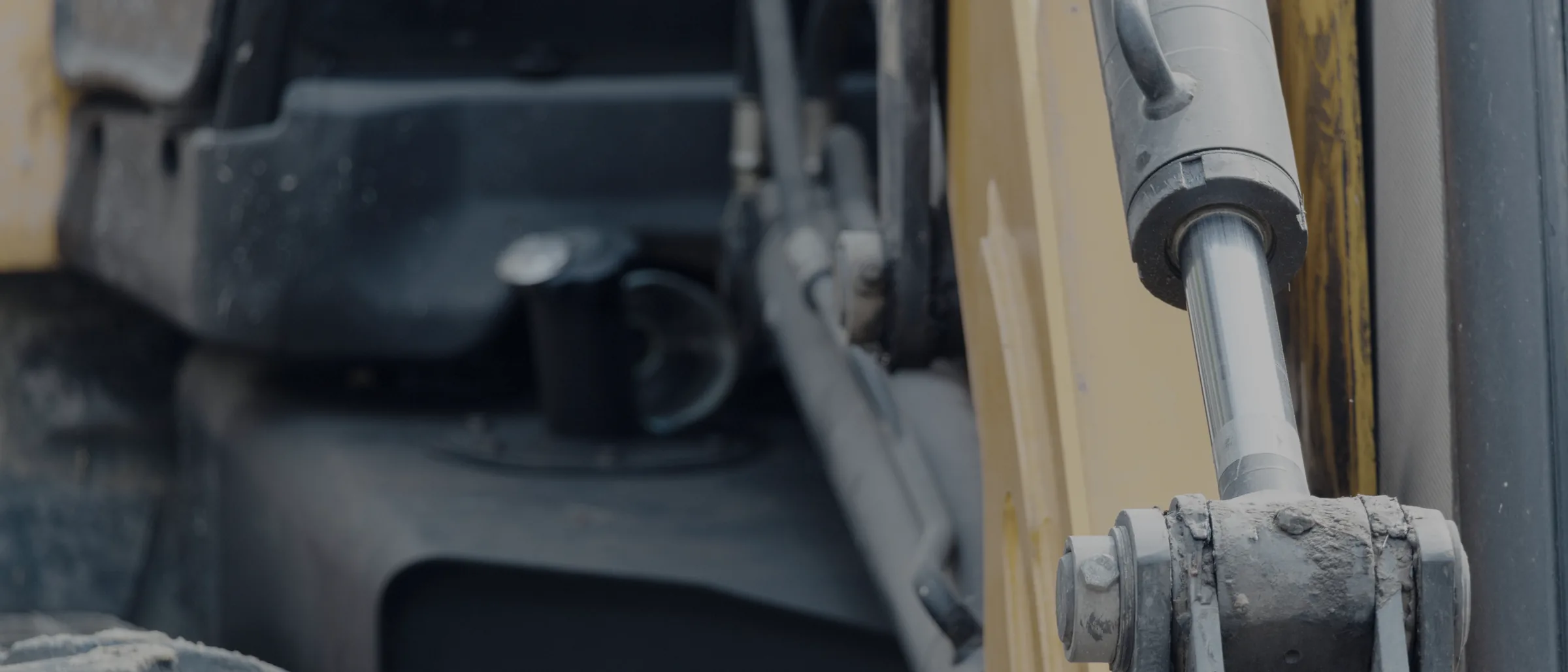 A hydraulic cylinder on an excavator arm, in the dust it works in