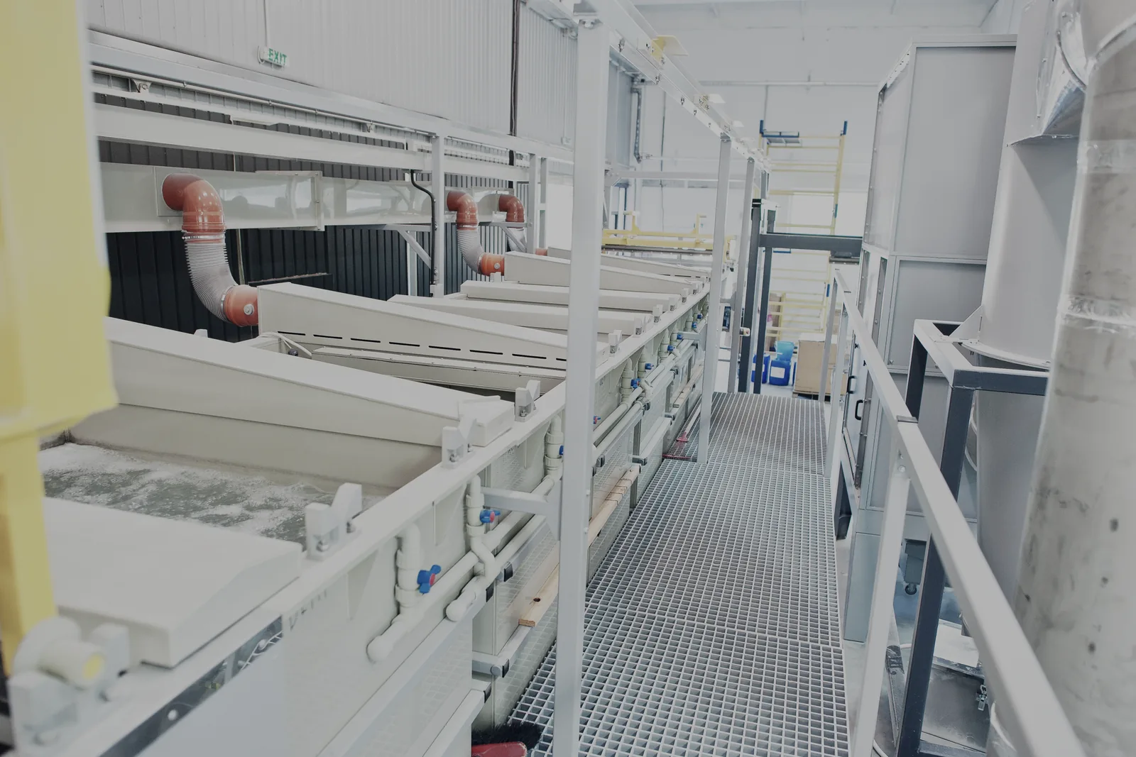 A conventional open-tank plating line: baths in a row, racks and an overhead crane above them