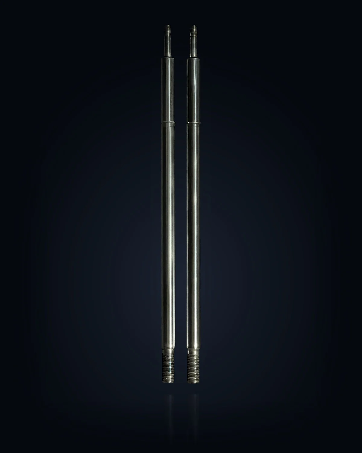 Two TripleHard® coated shock absorber rods, studio-lit against the page background
