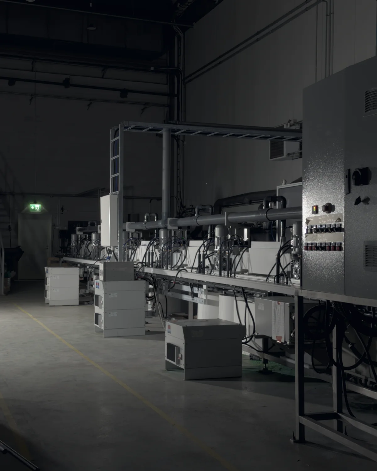 The industrial-scale prototype line in Kuopio, seen from the end of the line in the darkened hall
